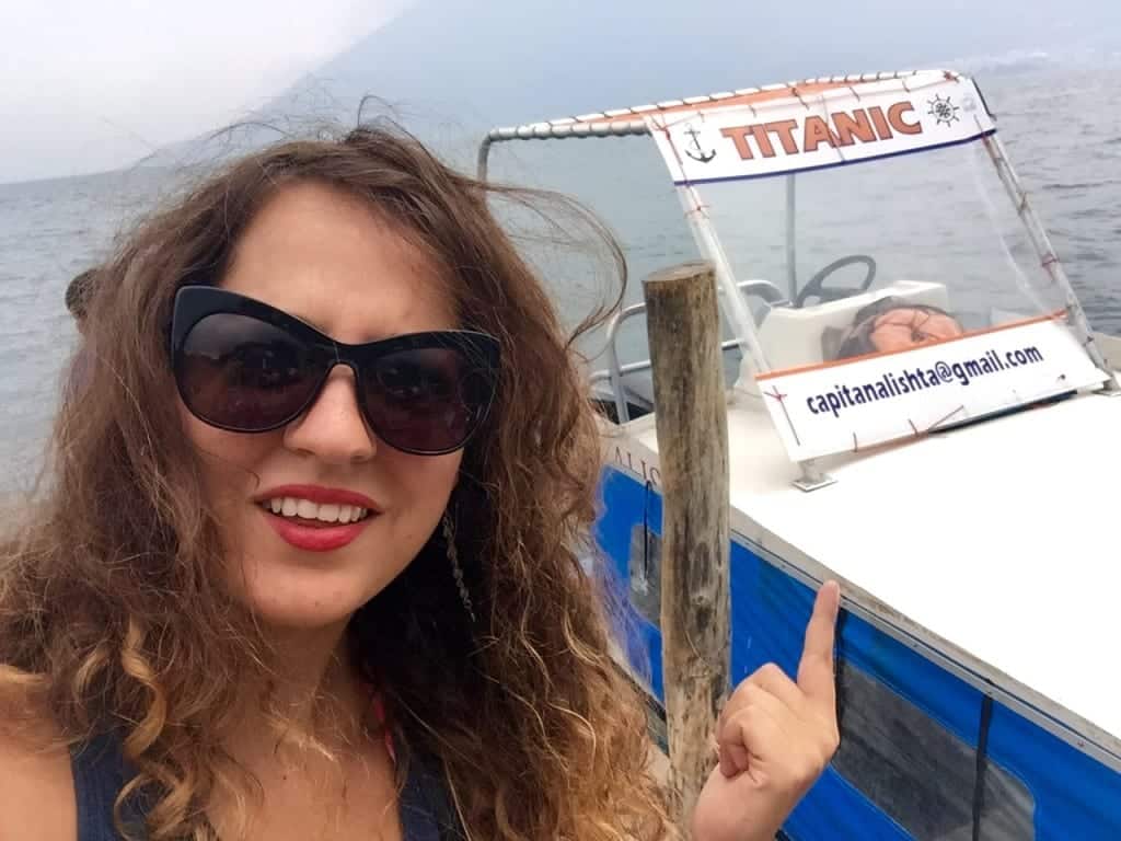 Kate stands in front of a small boat on Lake Atitlan named "Titanic." Kate points to it with an incredulous expression on her face.