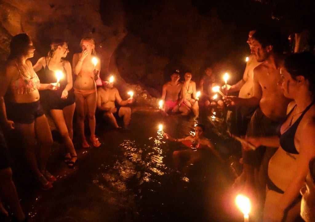 Friends in a cave holding candles