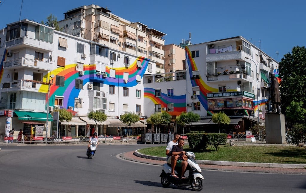 A white building in Tirana covered with a swirly rainbow.