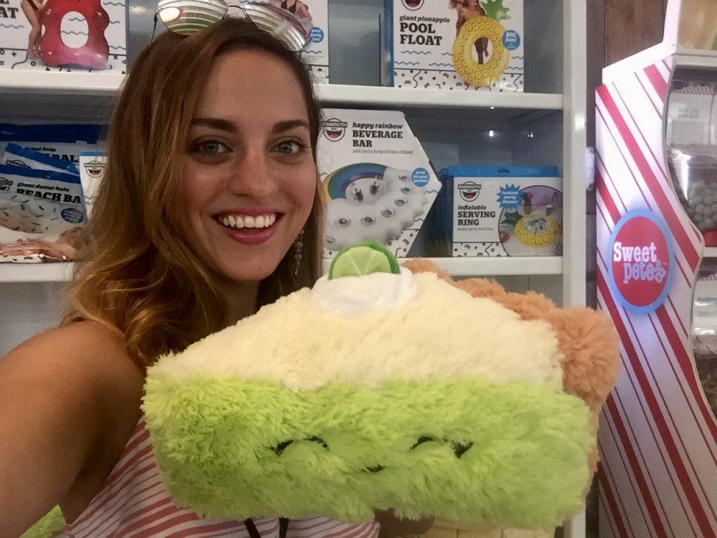 Kate holds a plush stuffed animal of a slice of key lime with a smile on its face.