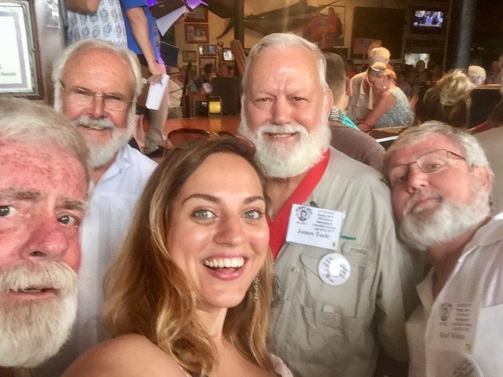 Kate taking a selfie with four Hemingway lookalikes in Key West, all with big white beards and wearing khaki shirts.