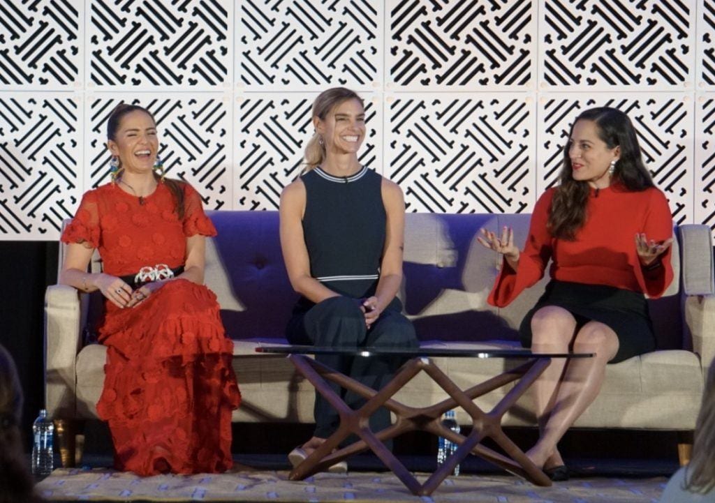 Kate speaking on a panel with two other women.