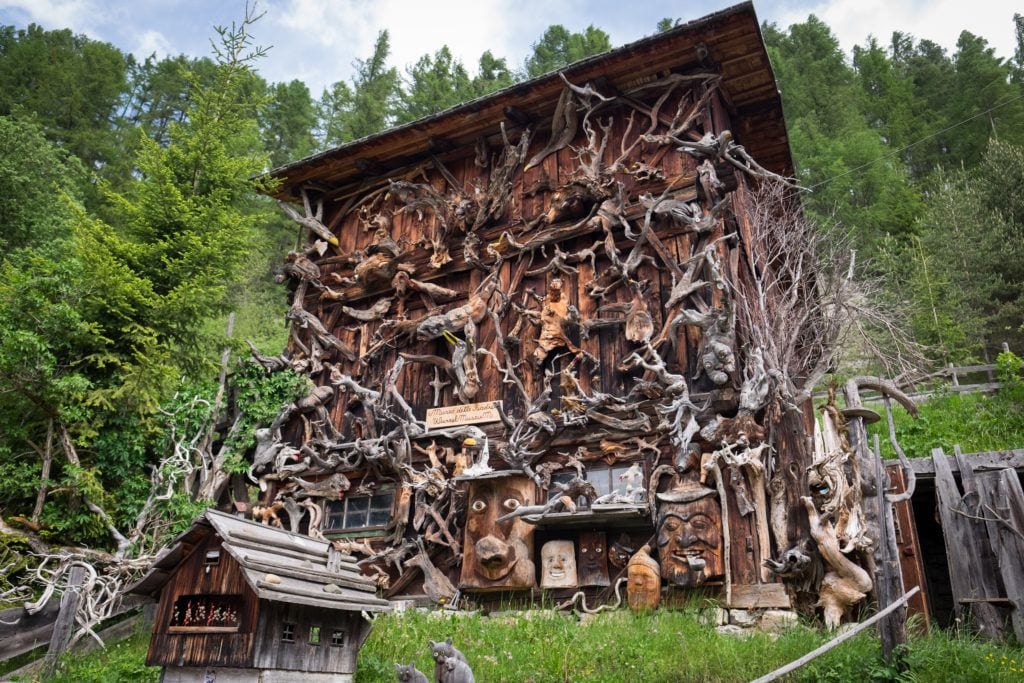 A wooden home in the Dolomites is covered with hundreds of wooden cutouts made from found pieces of wood.
