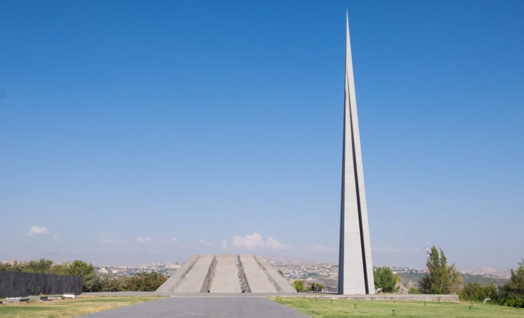 The trapezoid-shaped Armenian Genocide Memorial next to a tall, skinny tower.