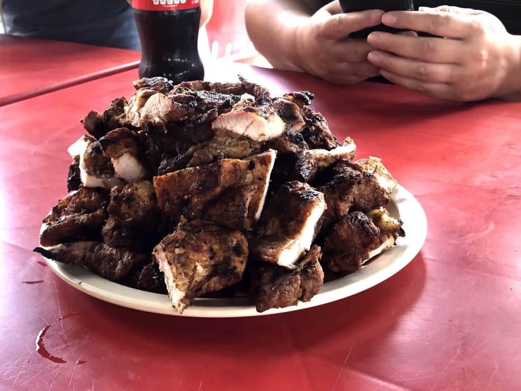 A HUGE plate filled with slabs of grilled pork.