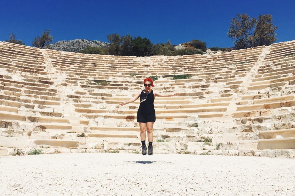 Katie jumping for joy in front of a Roman amphitheater.