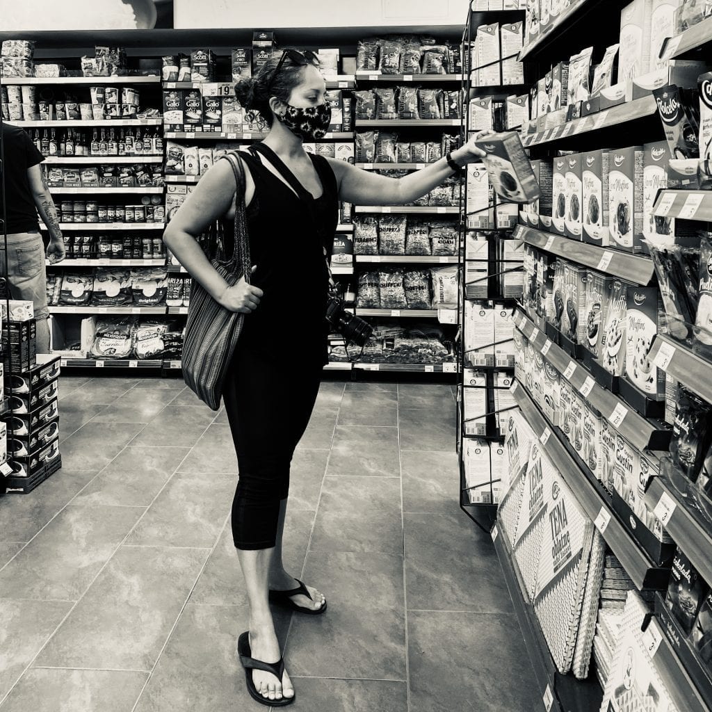 Kate wears a mask and shops for groceries.