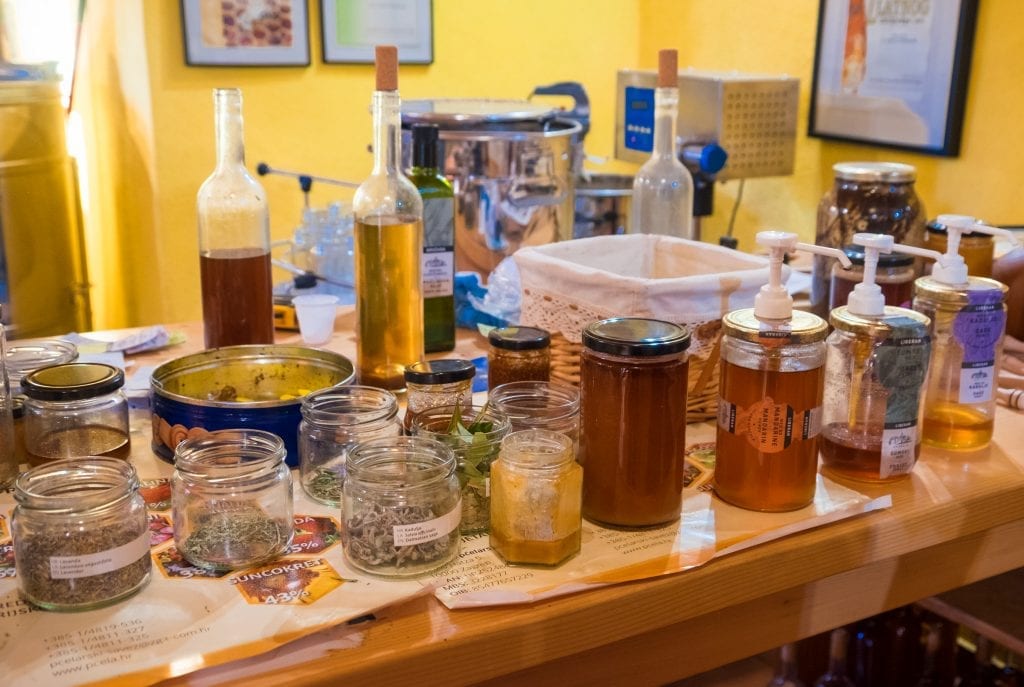 Stacks of herbs, honeys, and oils in a honey shop.