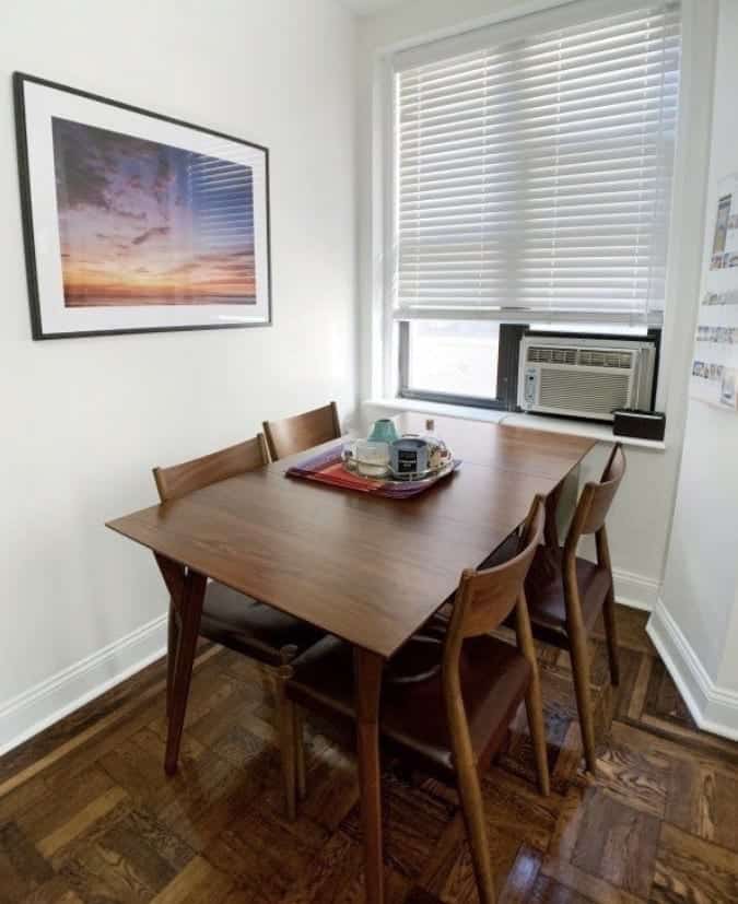 Kate's dark wood dining table and four wooden chairs with dark red leather seats.
