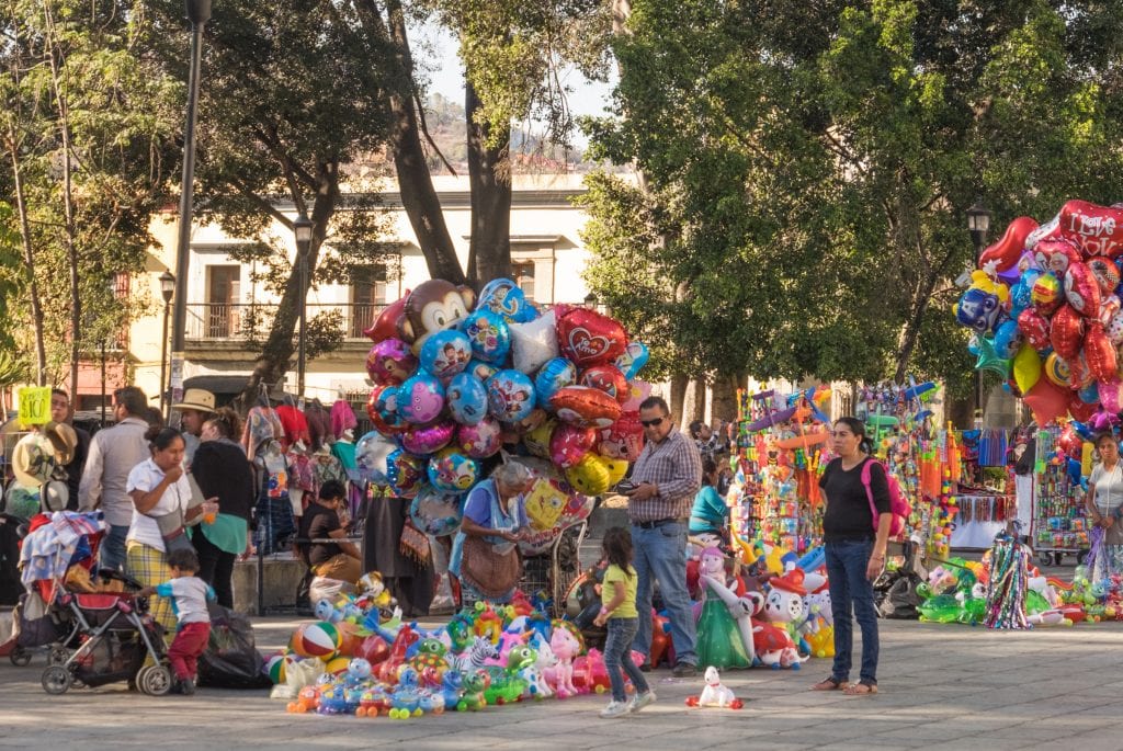A shot from the Zocalo: a man buying a balloon for his four-year-old daughter as her mother looks on.
