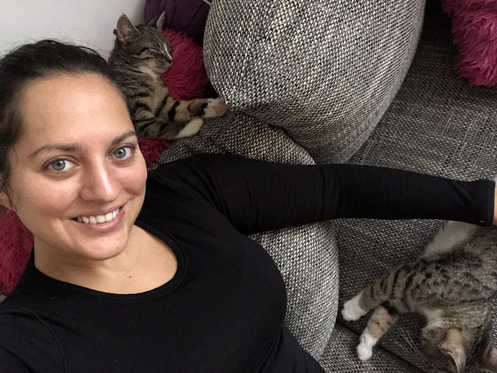 Kate takes a selfie on a gray couch with Lewis behind her shoulder and Murray next to her on the couch. Two gray tabby kittens with white paws.